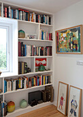 Gerahmte Kunst und Bücherregal am Fenster in einem Schlafzimmer in Essex UK