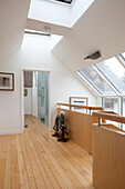 Schaukelpferd auf hölzernem Treppenabsatz mit Dachfenstern in einem Haus in Essex UK