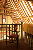 View of beamed ceiling from mezzanine landing with armchair