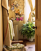 Badezimmer in Avocadogrün mit Vintage-Look, gefüllt mit Pflanzen, Blumen und Erinnerungsstücken