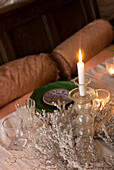 Detail of christmas table top with burning candle and silver centrepiece