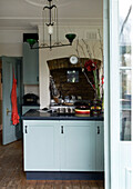 Nische mit Kochfeld in einer Küche mit pastellblauen Schranktüren