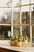 Old Post Office bay window decorated with paper snowflakes and hyacinth vases