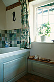 Weinreben-Gitterstoff im Badezimmer mit muschel- und steinverzierten Regalen und grünen Keramikfliesen
