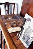 Alter Koffer auf einem Stuhl mit Kunstwerken in einer französischen Wohnung