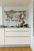 Utensil rack and kitchenware above kitchen sink and drawer unit