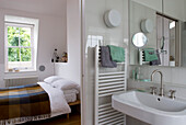 Weißes Bad und Schlafzimmer mit karierter Decke als Bettbezug