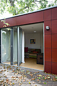 Sliding glass doors on garden extension with autumn leaves on decking