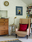 Armchair with brass lamp in corner of whitewashed room 