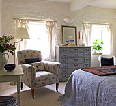 Floral patterned armchair in country bedroom with low ceiling