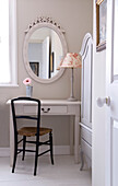 Ovaler Spiegel über Schminktisch mit Toile du j'ouy-Lampe und Holzstuhl