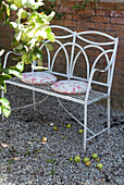 Cushions on metal garden seat covered in French print from Brocante Fabrics 