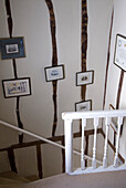 Flur mit Blick auf die Treppe und Balkenwand mit Bildern