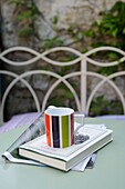 Cup newspaper and book on outdoor table