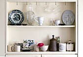 Collection of rustic crockery on kitchen shelf