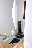 View on staircase with grandfather clock in modern house