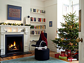 Beleuchtetes Feuer in einem weihnachtlich dekorierten Wohnzimmer