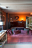 Beleuchtete Kerze auf einem Sofa in einem Wohnzimmer mit Holzbalken in Wiltshire
