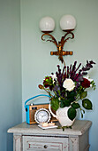 Cut flowers and radio with art deco lighting on bedside cabinet