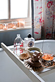 Lit candles and brushes on bath rack in Hereford bathroom