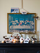 Religious artwork and lit candles on mantlepiece in London home