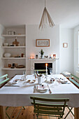 Lit candle on dining table in London home with recessed shelving