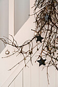 Silver baubles and star shaped decorations on pine branch in London home