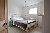 Woolen blanket on metal framed bed in Richmond home