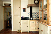 Devon kitchen with built-in storage and patterned tile splashback above range oven