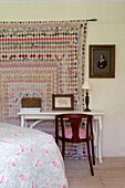 Patchwork quilt hangs on wall of Devon bedroom
