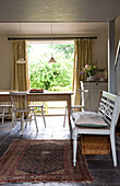 Open plan dining room with bench and rug