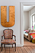 Gepolsterter Sessel unter dem übergroßen Buchstaben U im Flur eines modernen Familienhauses in Odense Dänemark
