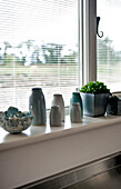 Cactus and glazed pots on windowsill in Suffolk home England UK