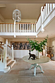 Metal hare statue on a pedestal base table with leaf arrangement in spacious entrance hallway of Canterbury home England UK