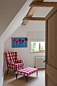 Sessel und Fußbank im Gingham-Karo mit moderner Leinwand im Schlafzimmer eines Hauses in Canterbury, England UK