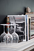 Verstaubte Weingläser und Fachbücher auf dem Kaminsims in einem historischen Haus in Yeovil, Somerset, England, UK