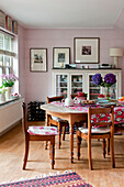 Esstisch und Stühle aus Holz mit Glasvitrine in einem Londoner Haus UK