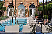 Sunlit swimming pool and brick exterior of West London townhouse England UK