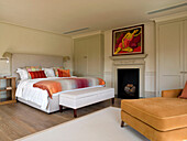 Modern art above fireplace in master bedroom of West London townhouse England UK