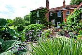 Garten eines Landhauses aus Backstein in Suffolk England UK