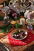 Vintage Christmas ornaments with a bowl of nuts on wooden table in Forest Row home, Sussex, England, UK