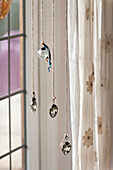 Vier Glaskugeln hängen im Fenster des Hauses der Familie Forest Row, Sussex, England, UK