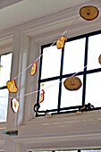 Dried apple on string, Christmas decoration at window in Forest Row family home, Sussex, England, UK