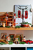 Kunstwerke und Ornamente mit Tannennadeln auf Regalen im Haus der Familie in Forest Row, Sussex, England, UK