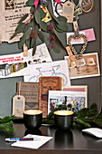 Pinnwand-Memorabilia und Teelichter auf dem Schreibtisch in einer Wohnung in Paris, Frankreich