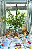 Easter eggs and teapot with spring blossom on table in Essex home, England, UK