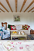 Patchwork cushions on sofa with harp in beamed living room of Essex home, England, UK