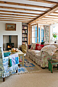 Beamed living room with wood burning stove in Essex home, England, UK