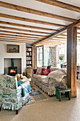 Beamed living room with wood burning stove in Essex home, England, UK