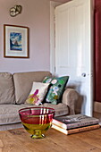 Glass bowl and books on wooden coffee table in living room of Bovey Tracey family home, Devon, England, UK